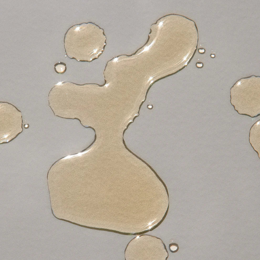 Close-up of beige oil droplets on a gray background